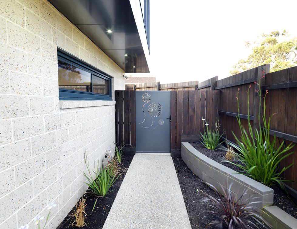 A brick building with a wooden fence and a walkway leading to it