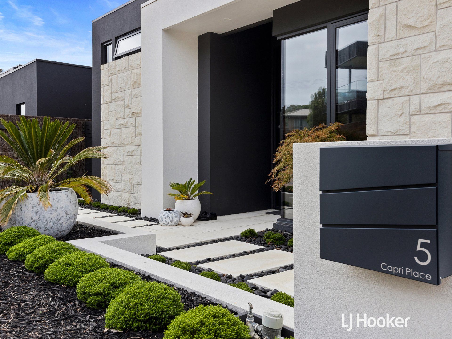 A modern house with a black mailbox in front of it