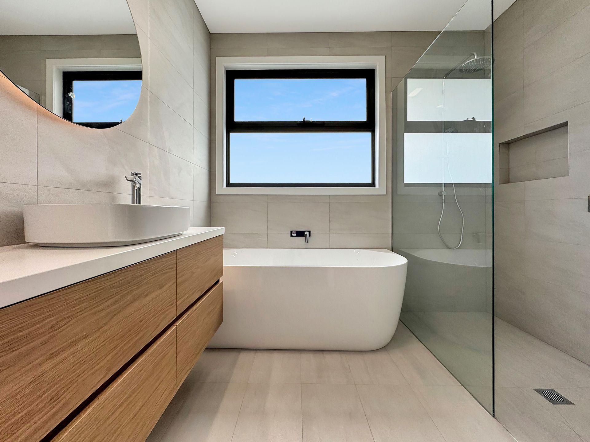 A bathroom with a tub , sink , mirror and walk in shower.