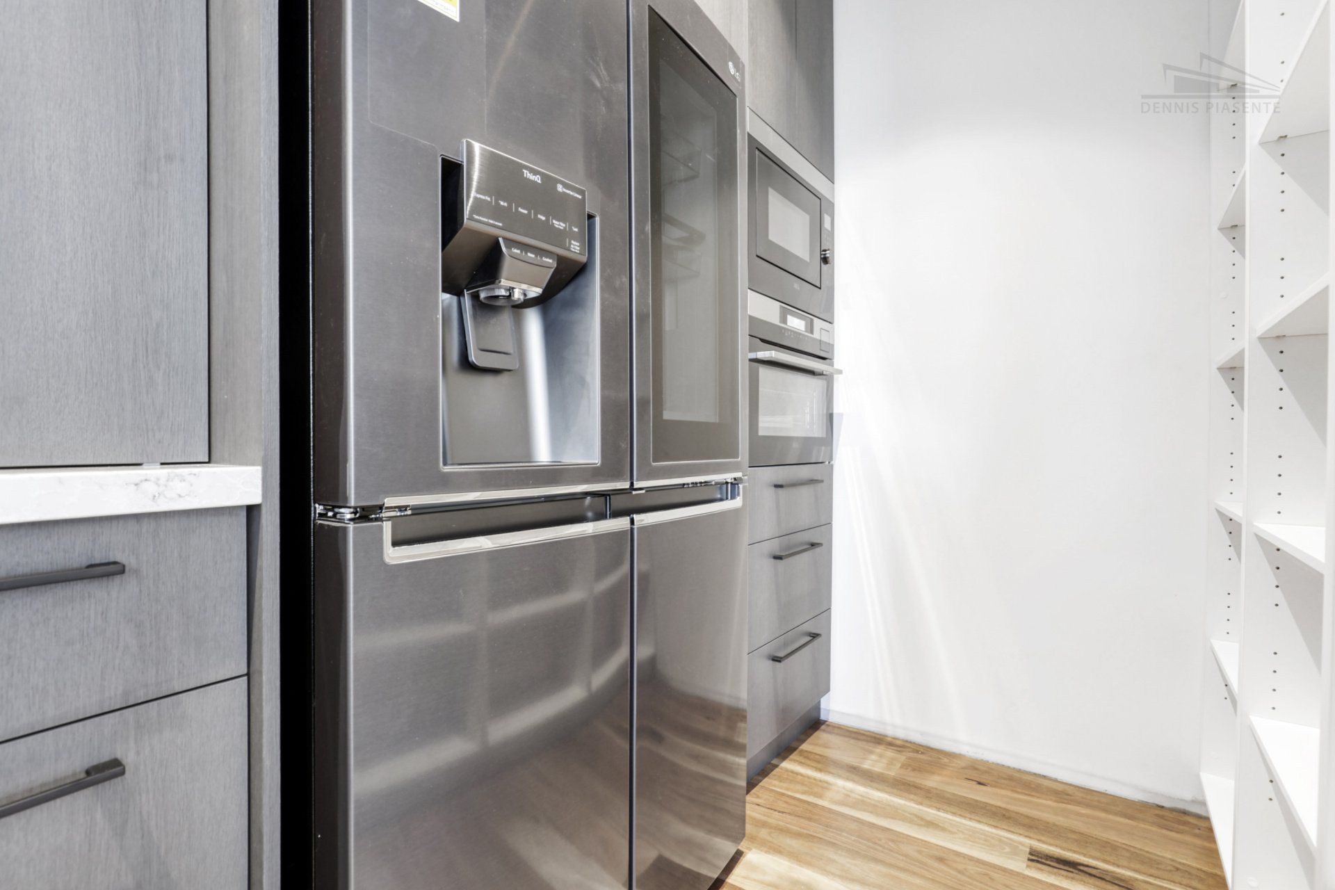 A stainless steel refrigerator and freezer are in a kitchen.