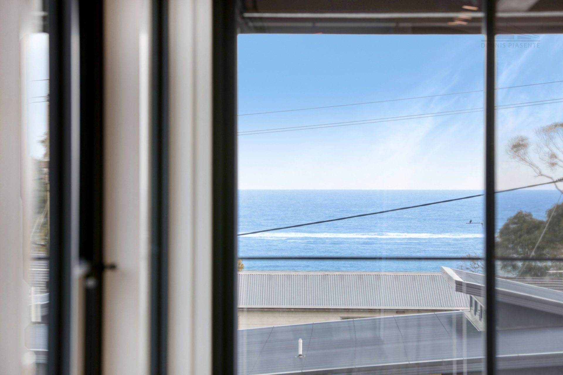 There is a view of the ocean through a window.