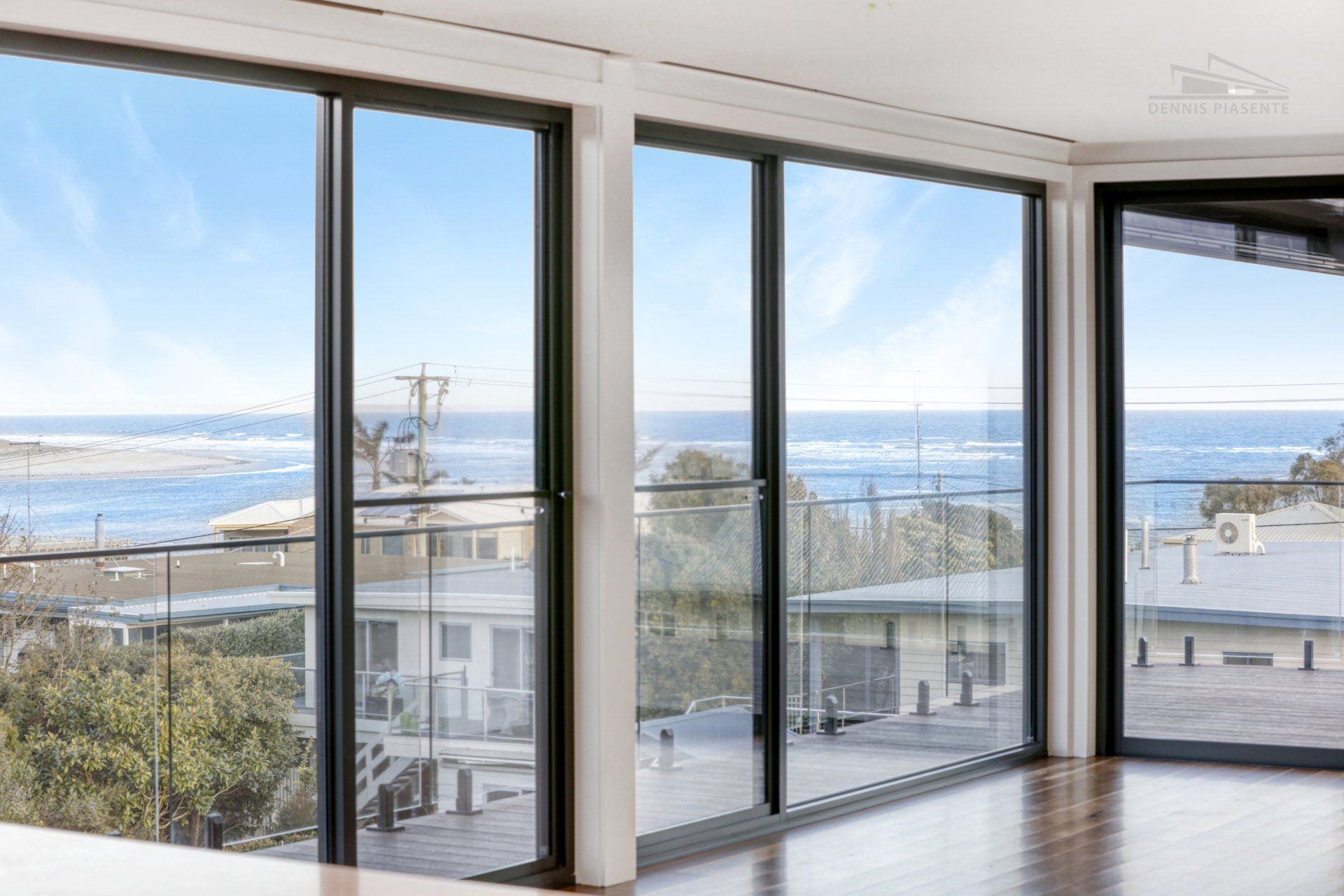 A large room with a lot of windows and a view of the ocean.
