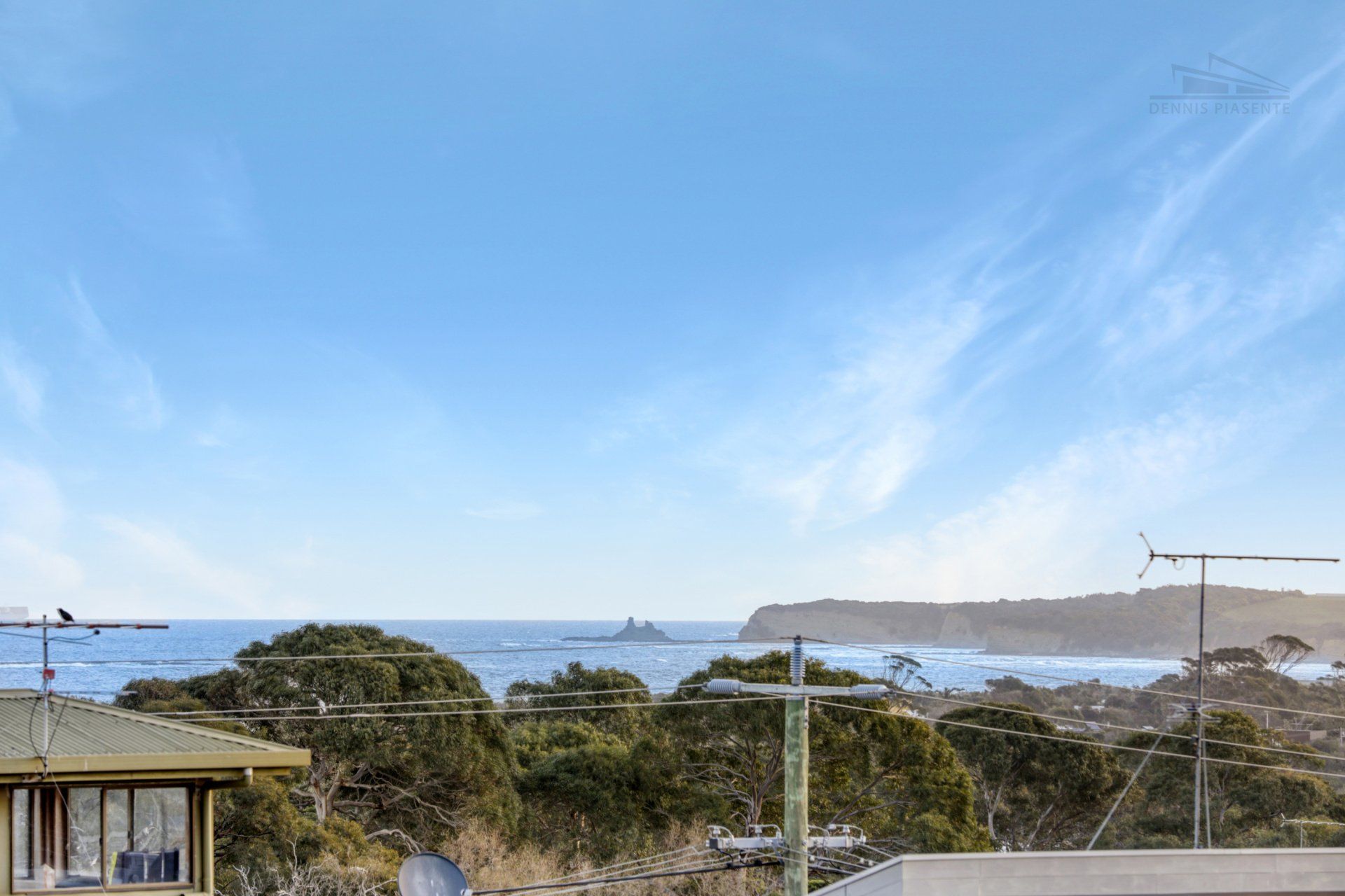 There is a view of the ocean from the roof of a house.