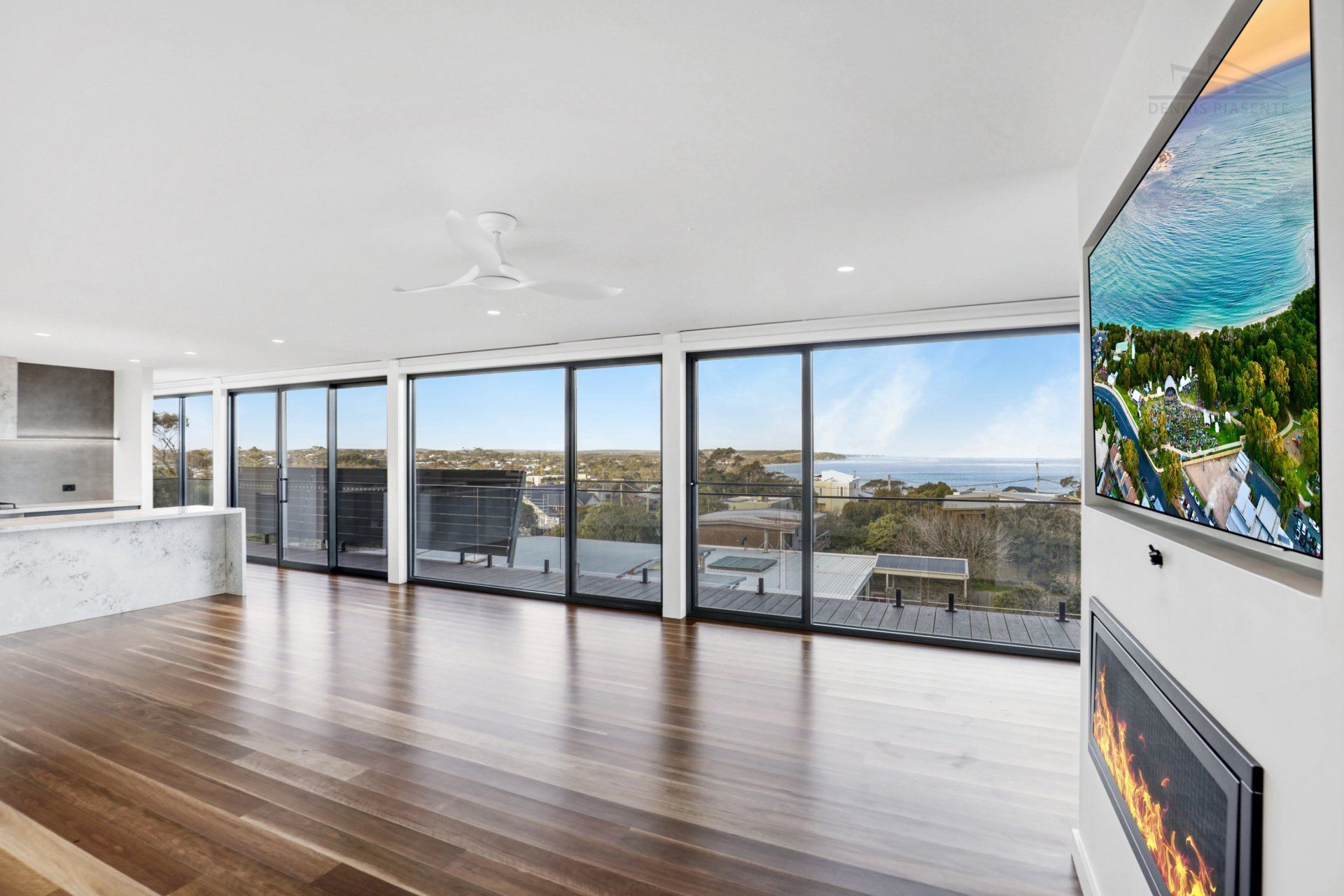 A living room with a fireplace and a flat screen tv on the wall.