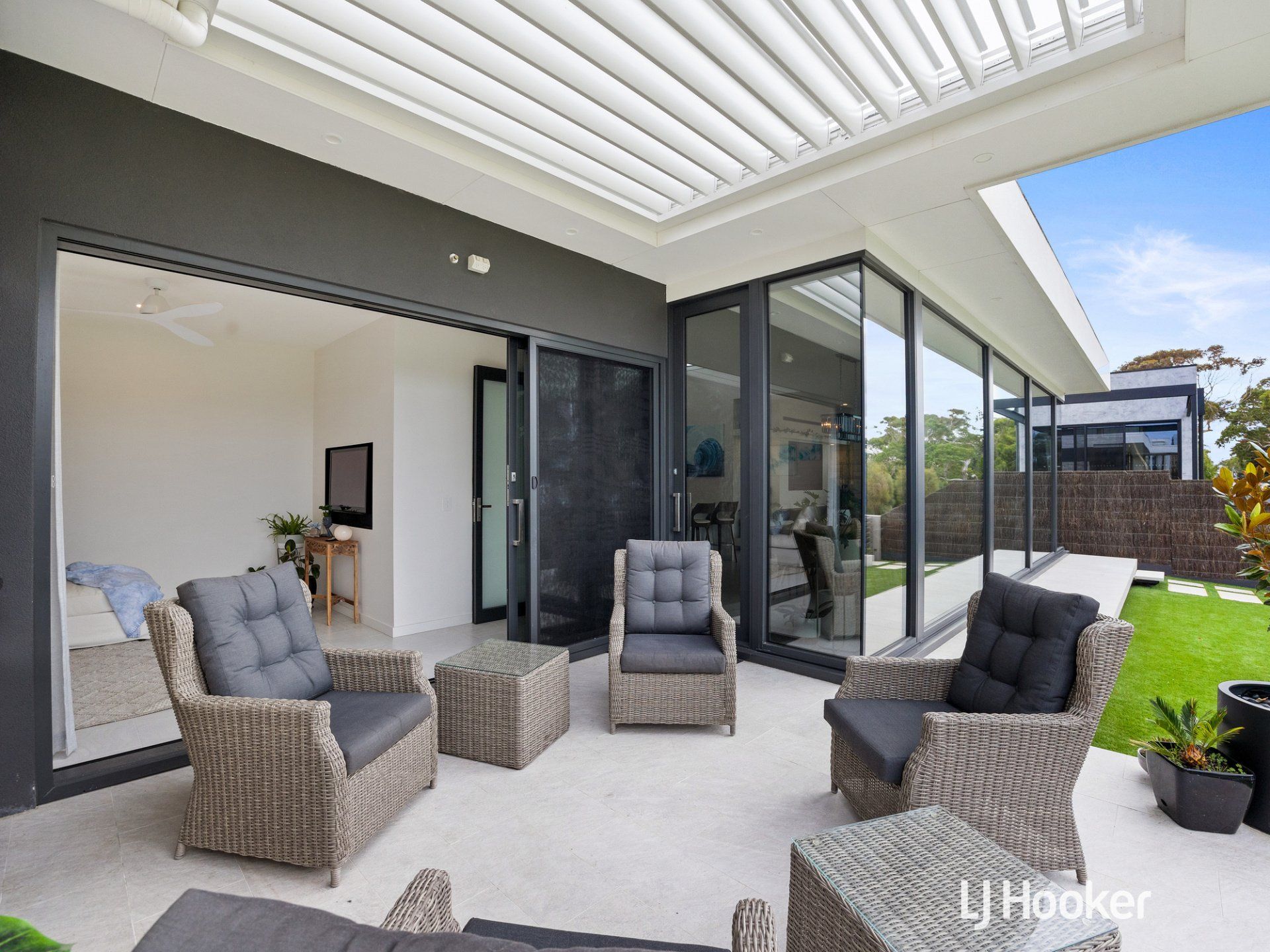 A patio with chairs and tables in front of a house