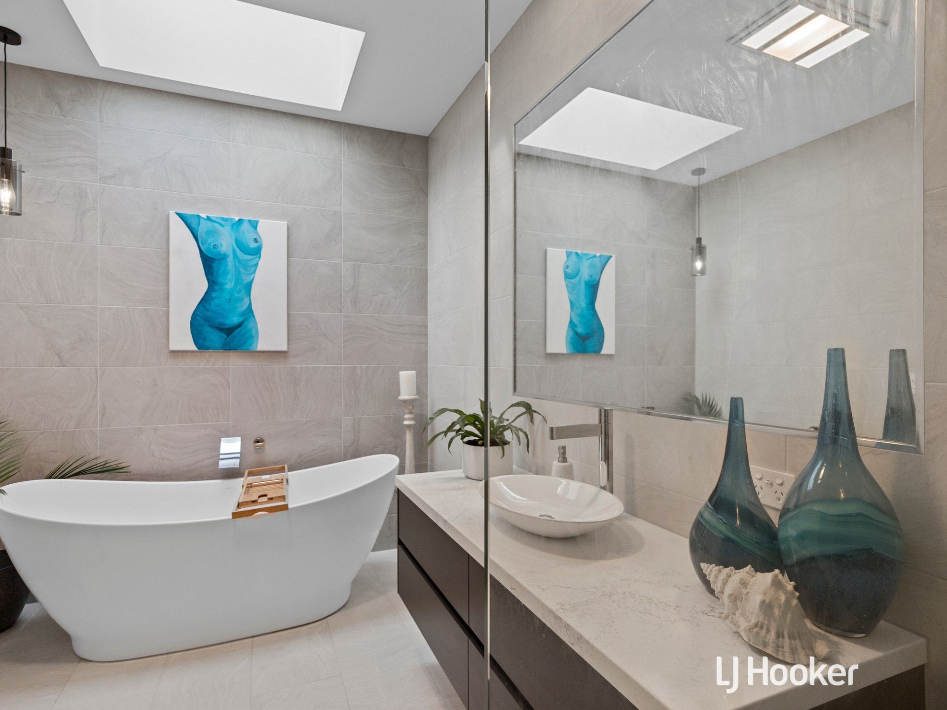 A bathroom with a bathtub , sink and mirror.