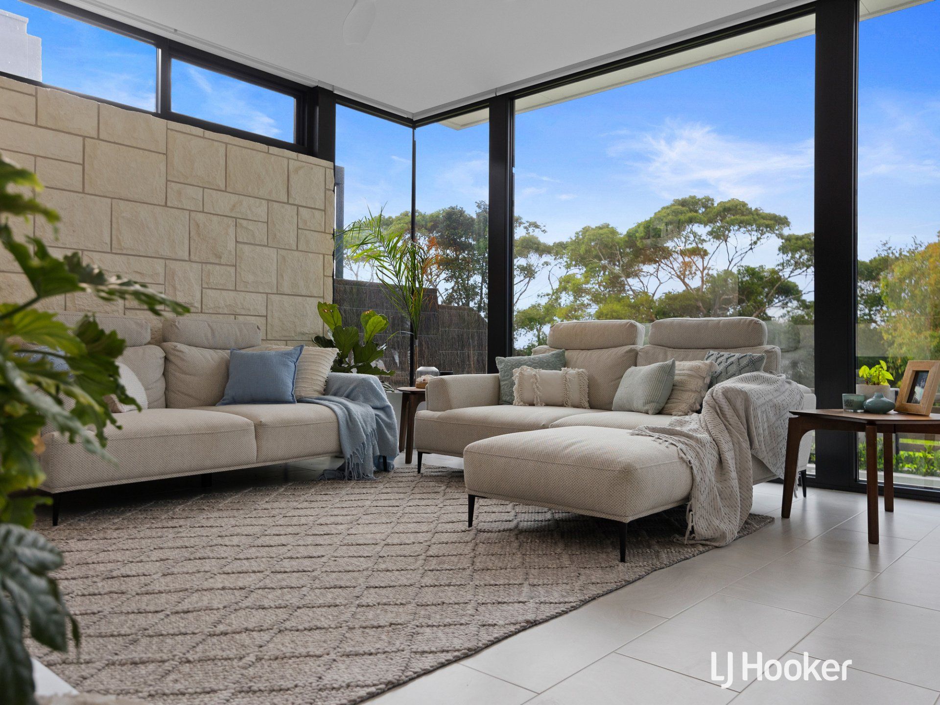 A living room with a couch and chairs and a rug.