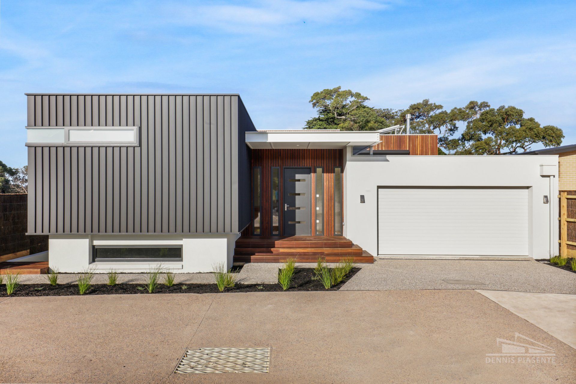 A modern house with a gray siding and a white garage door