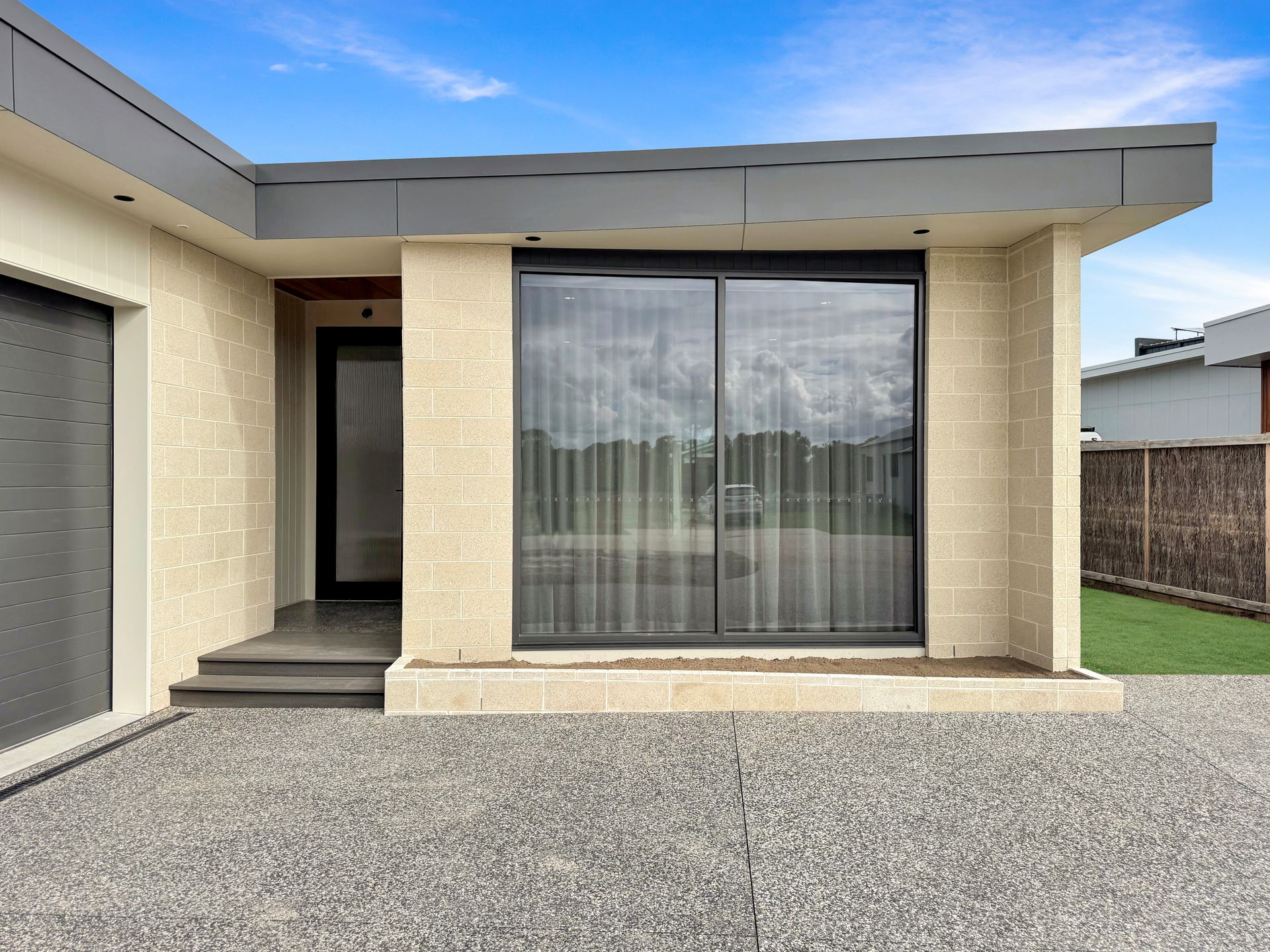 A small house with a sliding glass door and a garage.