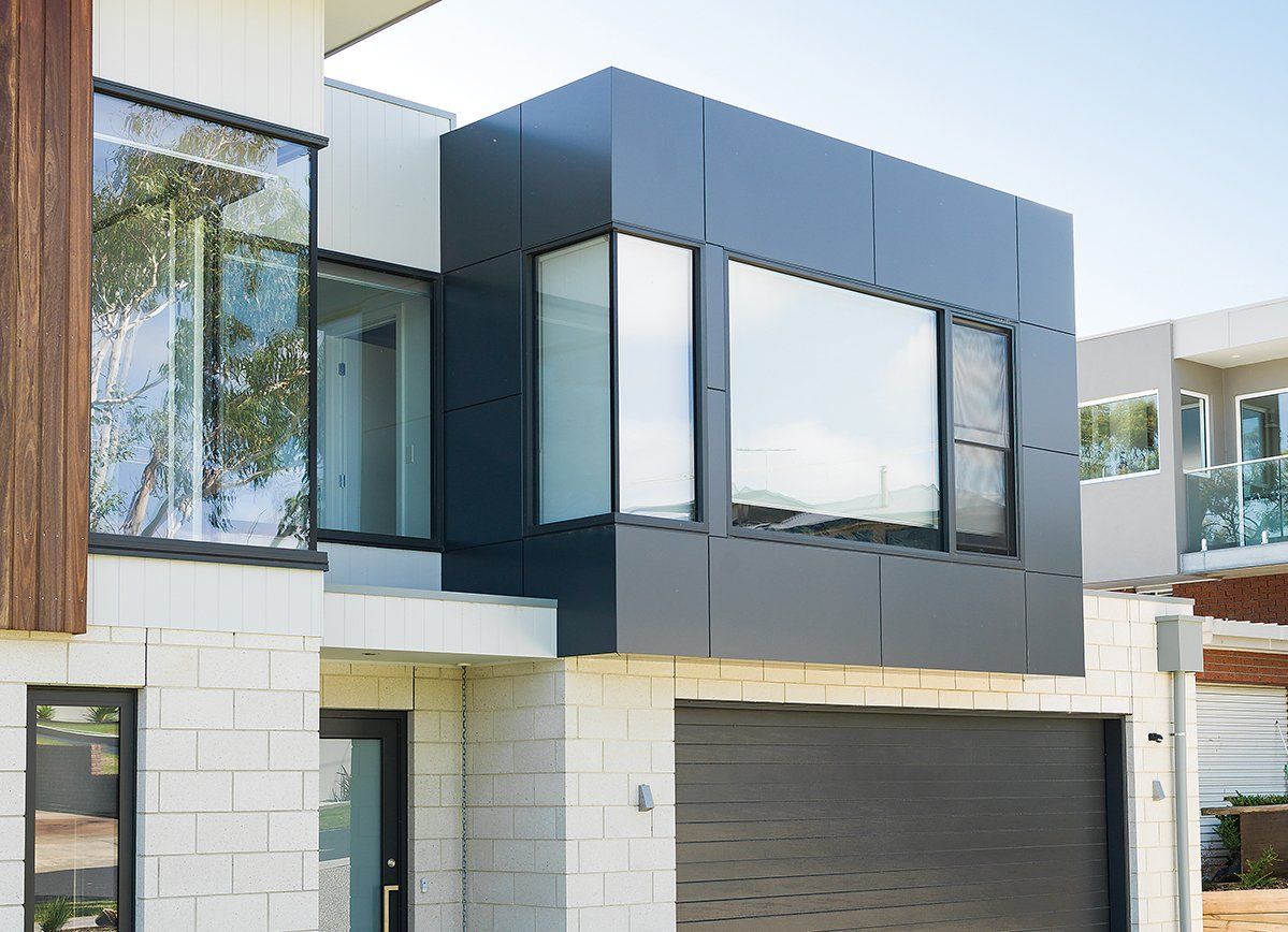 A modern house with a garage and a lot of windows.
