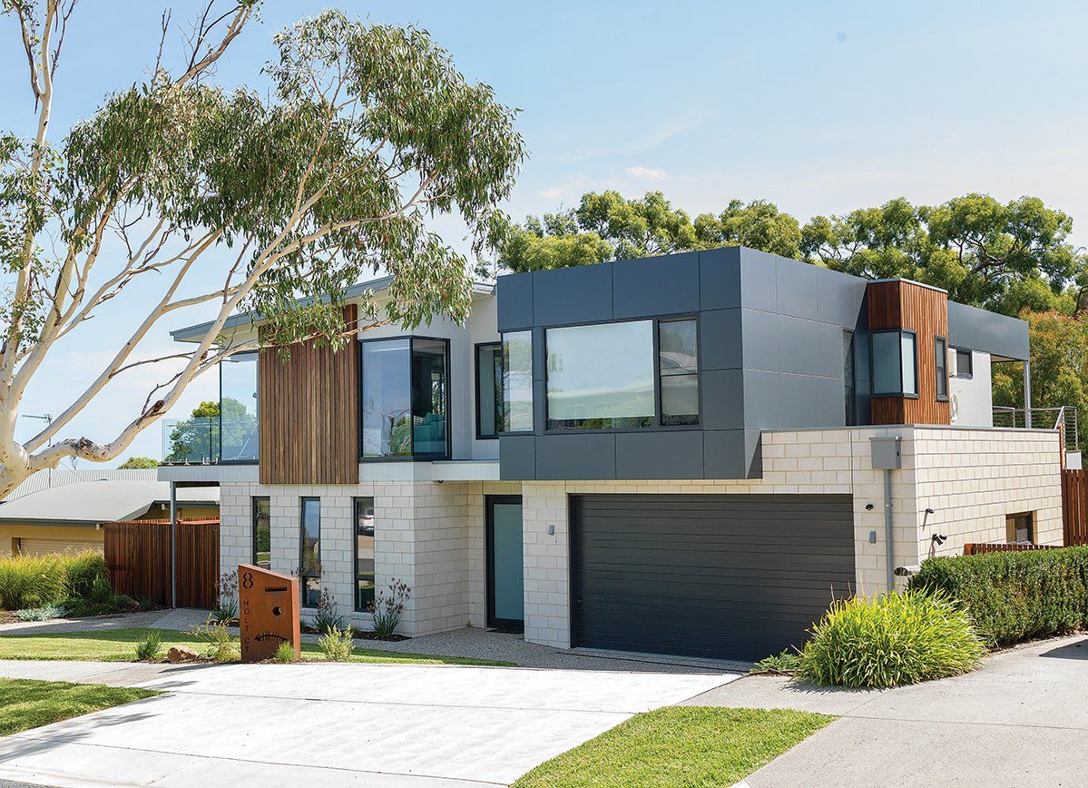 A modern house with a large garage and a lot of windows.