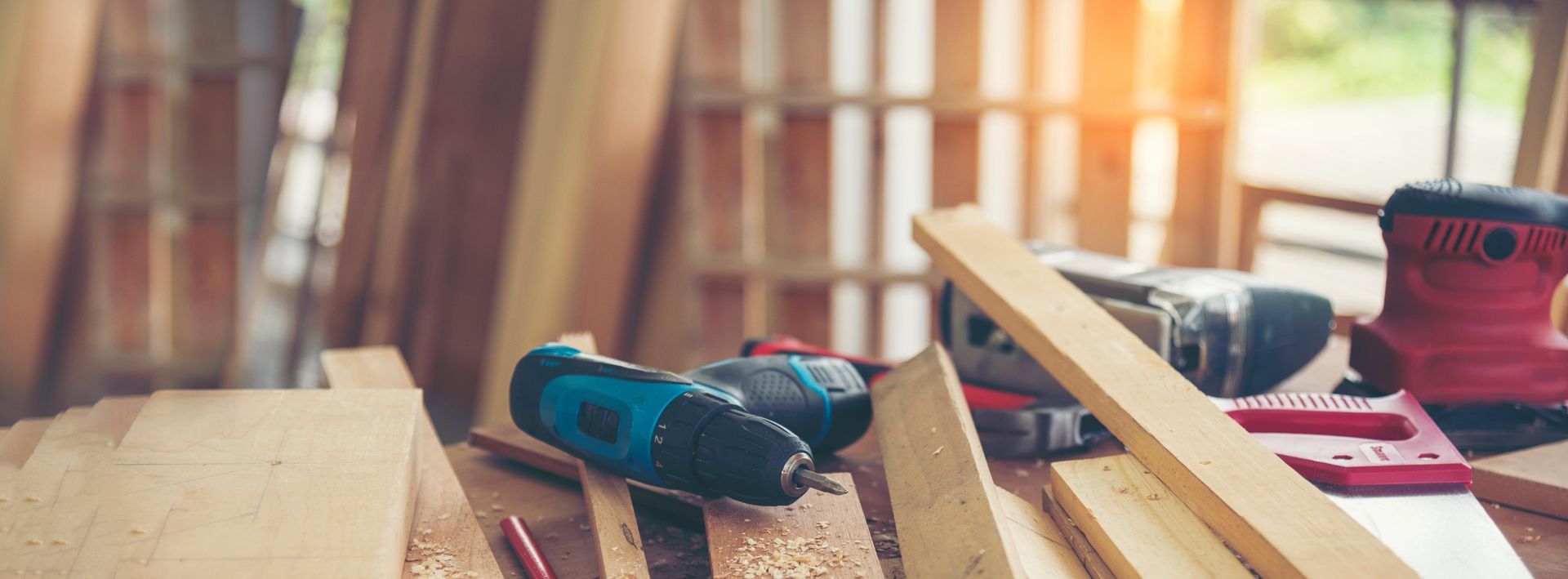 A wooden table with a drill and other tools on it.