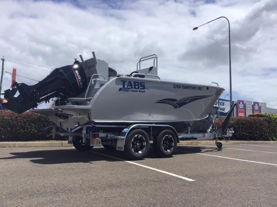 A Silver Tabs Boat On A Trailer, Parked In A Lot Under A Cloudy Sky — In Tune Marine in Mackay, QLD