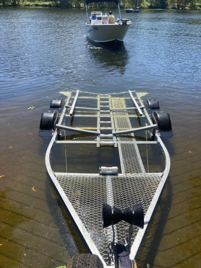 Boat Trailer Submerged In Water; Boat In The Distance — In Tune Marine in Mackay, QLD
