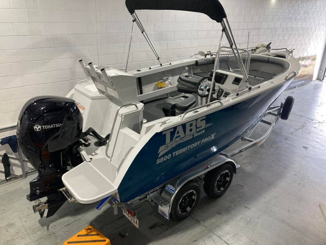 Blue And Silver Tabs Territory 600 Boat On A Trailer, Black Motor, Parked Indoors — In Tune Marine in Mackay, QLD