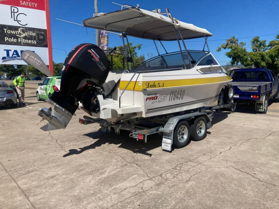 Boat On A Trailer With Black Outboard Motor And A Sunshade, Parked Outside A Business On A Sunny Day — In Tune Marine in Mackay, QLD