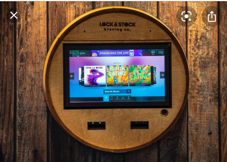 Claw machine filled with colorful plush toys; a silver claw descends over the toys.