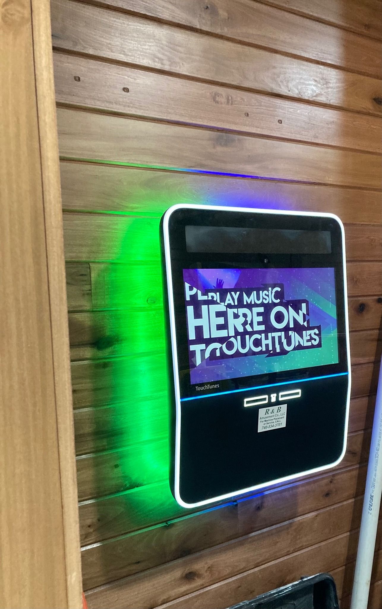 Claw machine filled with colorful plush toys; a silver claw descends over the toys.