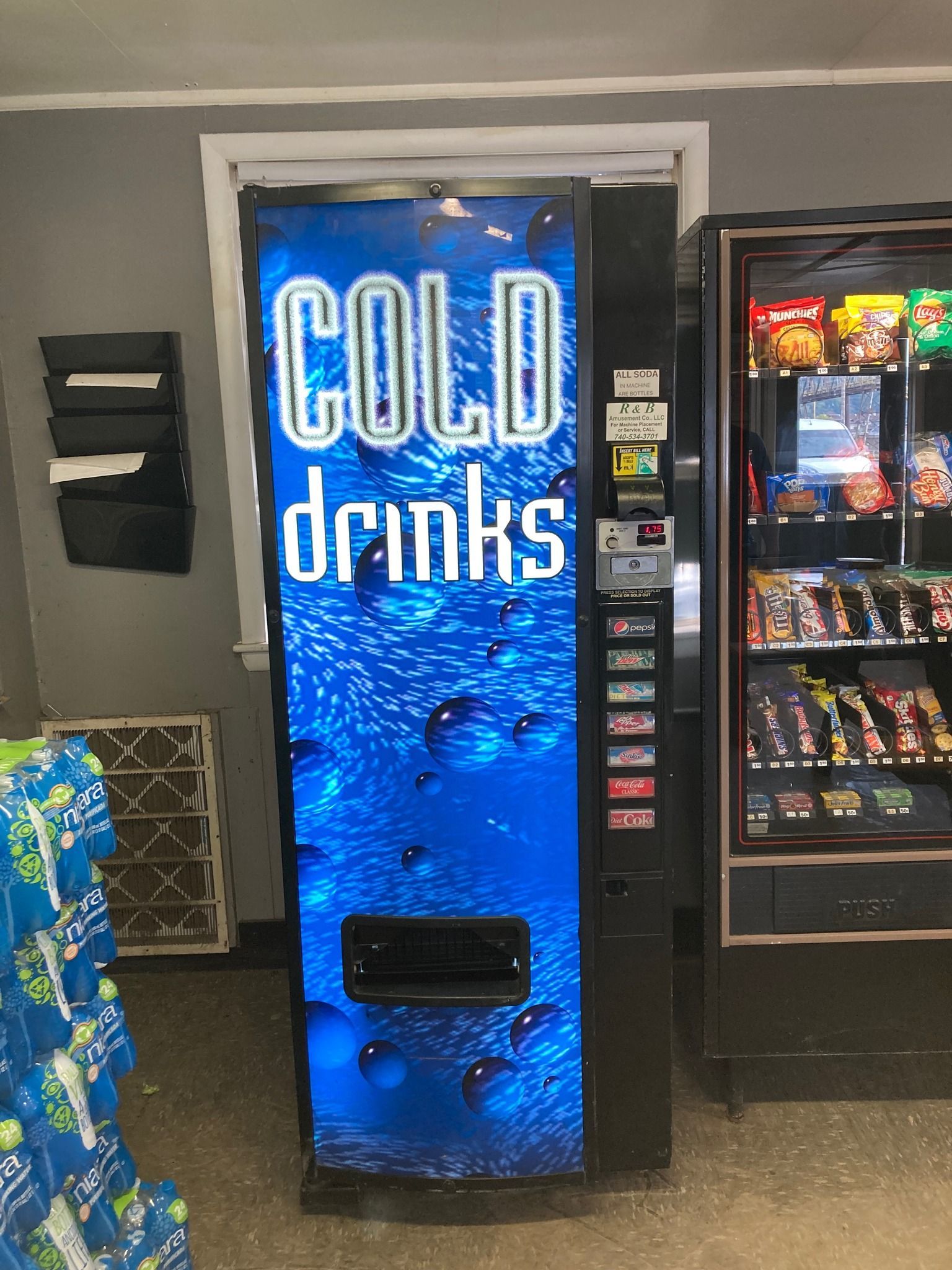 Claw machine filled with colorful plush toys; a silver claw descends over the toys.