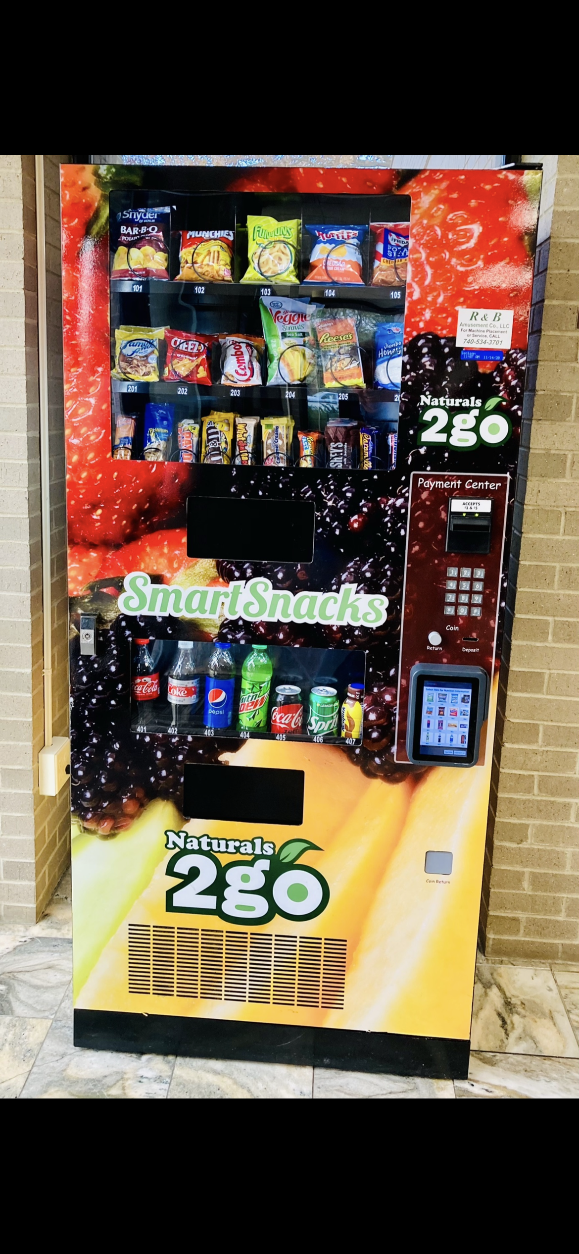 Claw machine filled with colorful plush toys; a silver claw descends over the toys.
