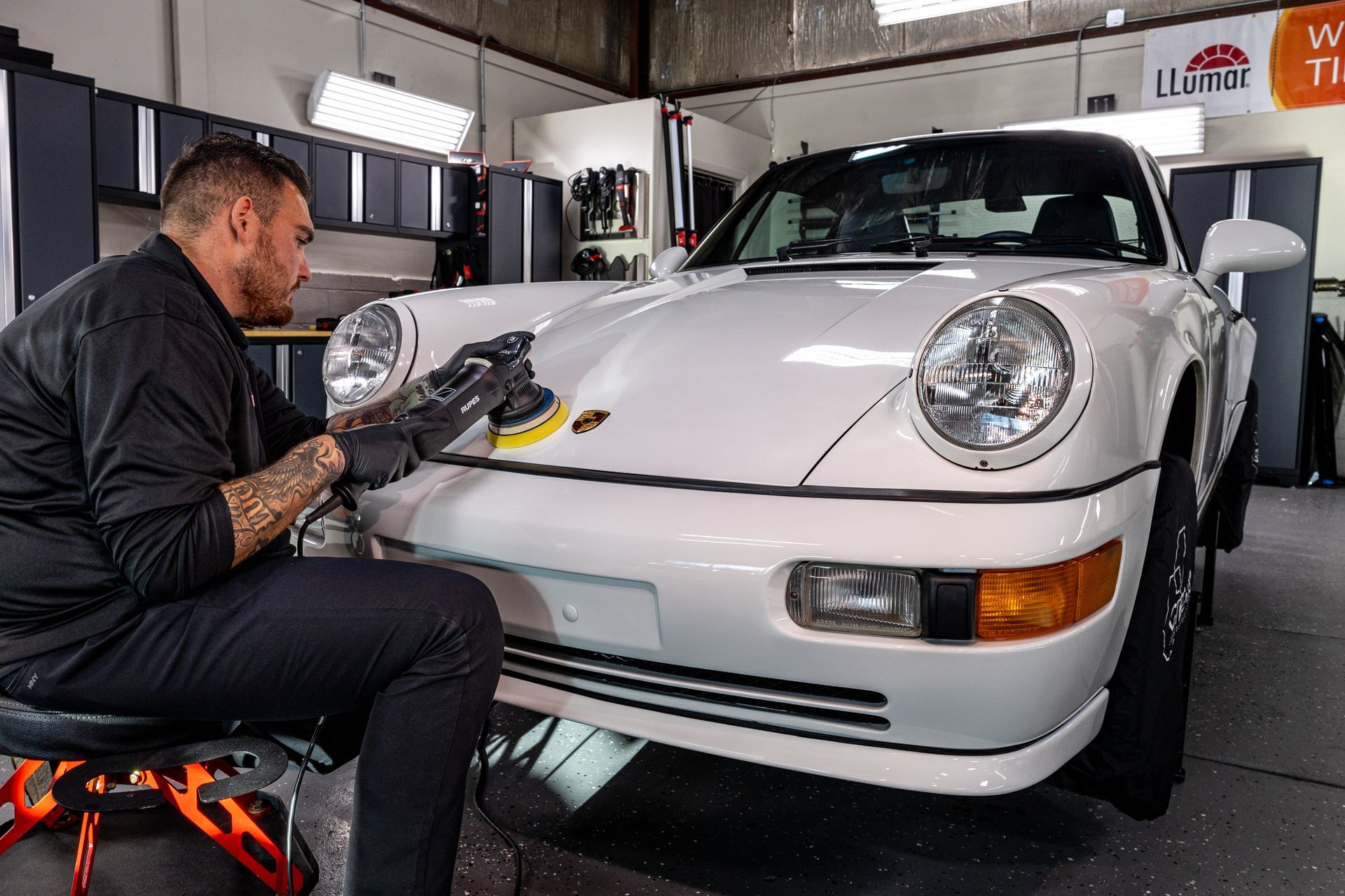 A blue car is sitting on top of a lift in a garage.