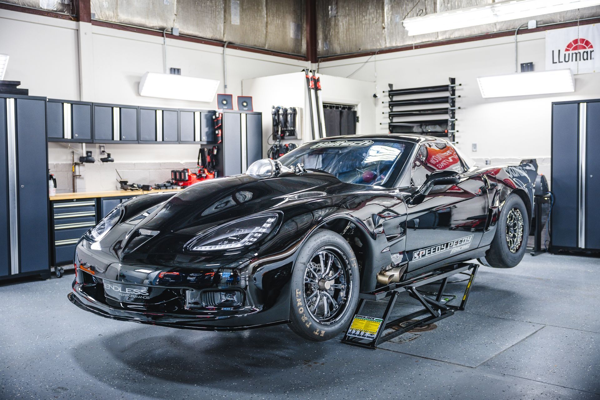 A red classic car is parked in a garage.