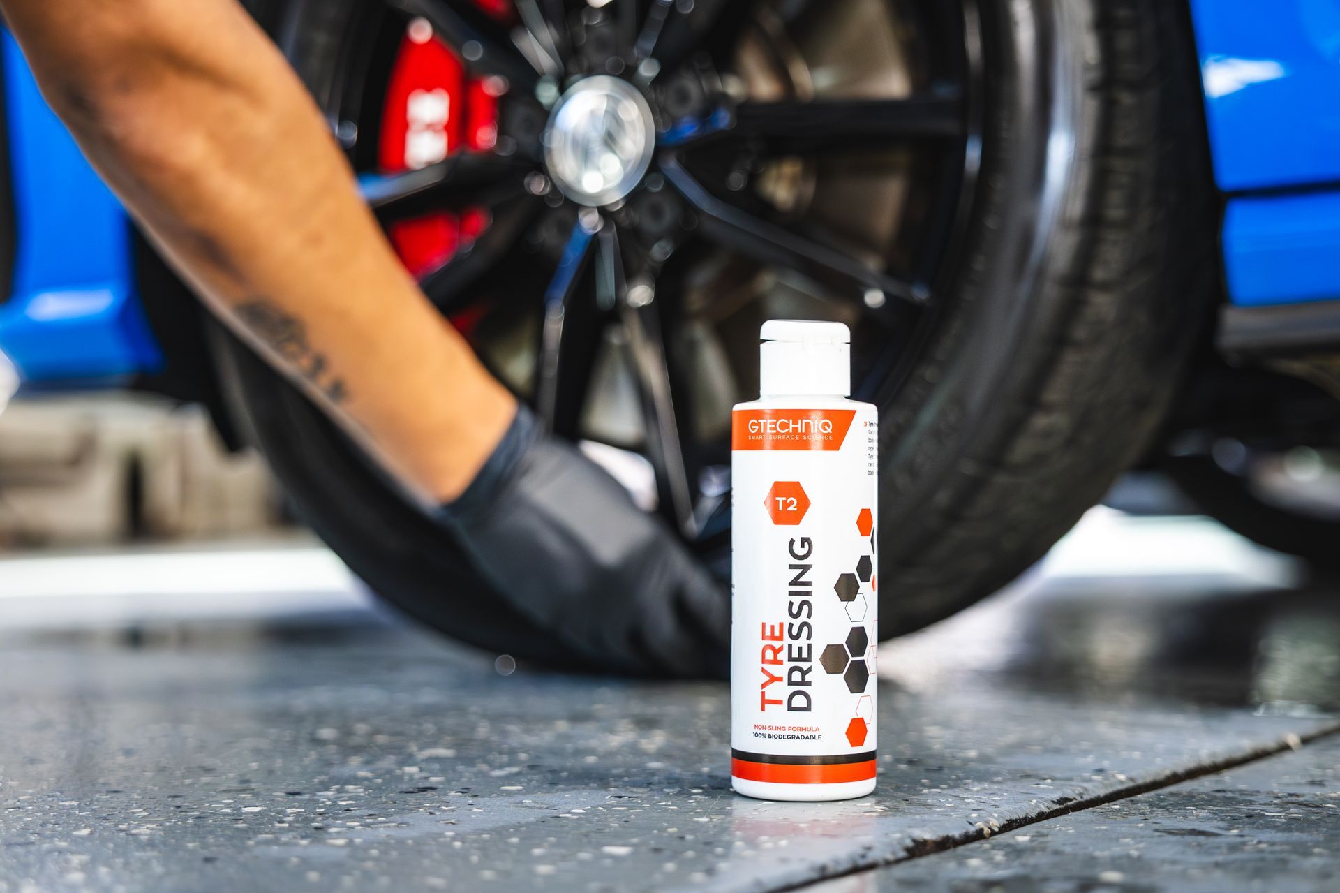 A red sports car is parked in a garage.