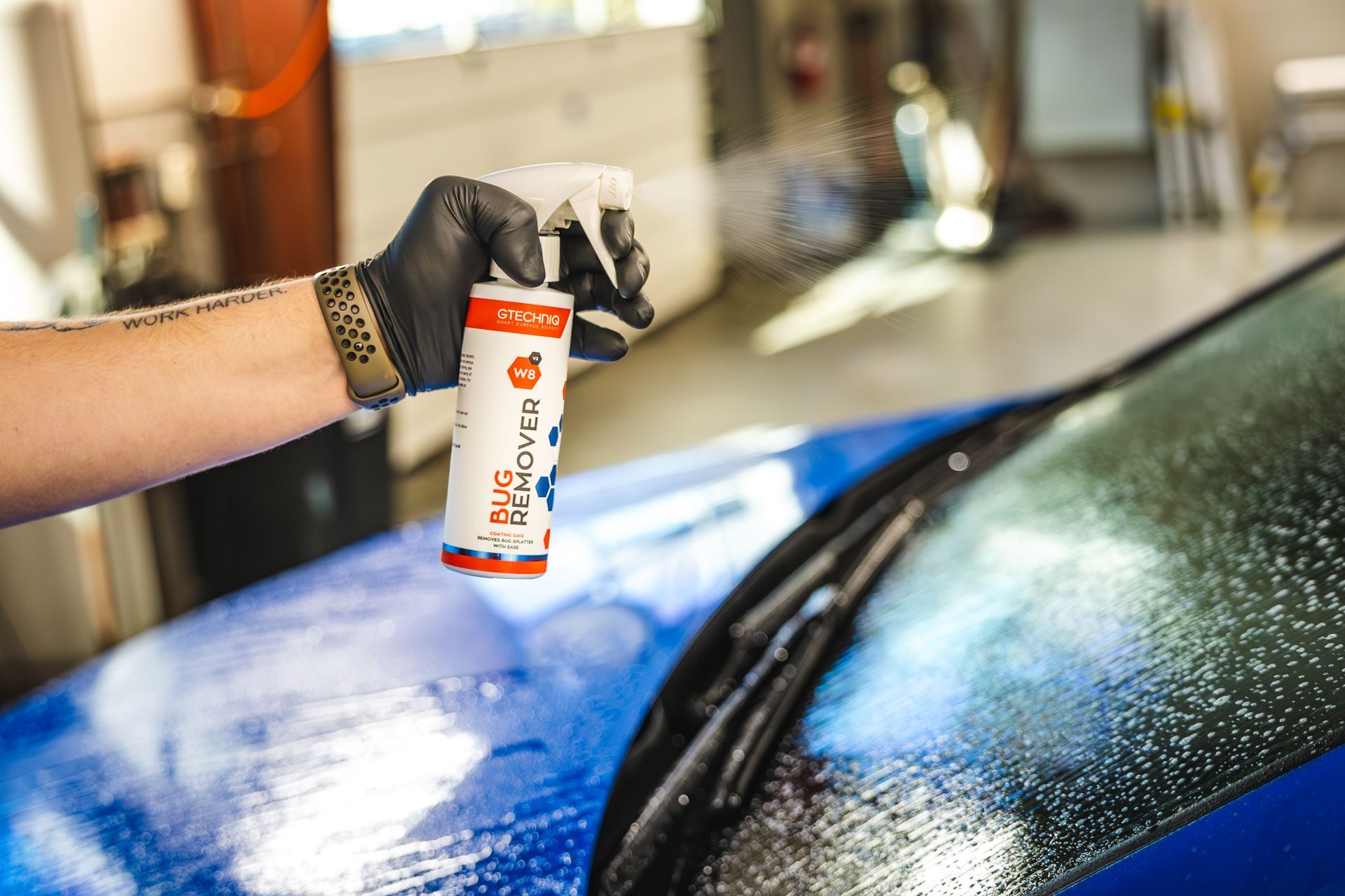 A person is washing a car with foam and a cloth.