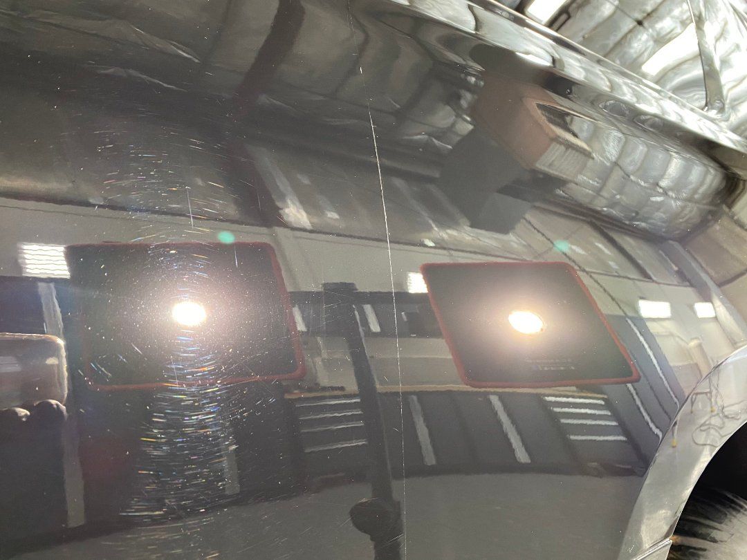 A close up of a car 's windshield with a reflection of a building in it.