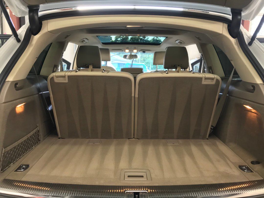 The back of a white suv with the trunk open.