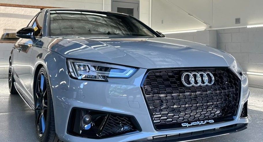 Gray Audi sedan with black accents, parked indoors.
