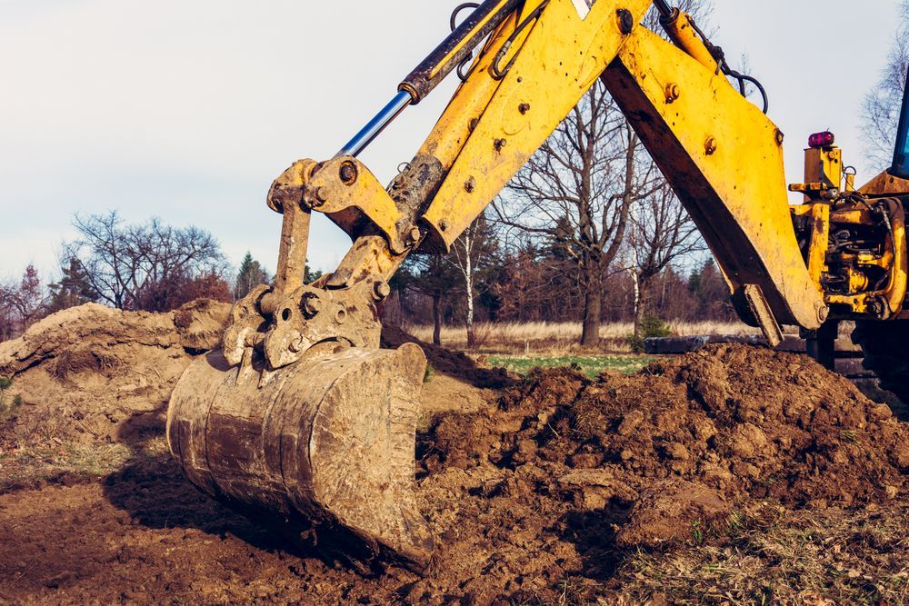 A Yellow Excavator Is Digging A Pile Of Dirt In A Field — JC Hire In Bli Bli, QLD