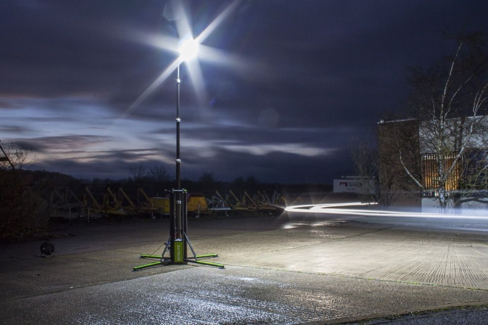 A portable telescoping antenna, standing on a tripod base. Green and silver with antennas at the top.