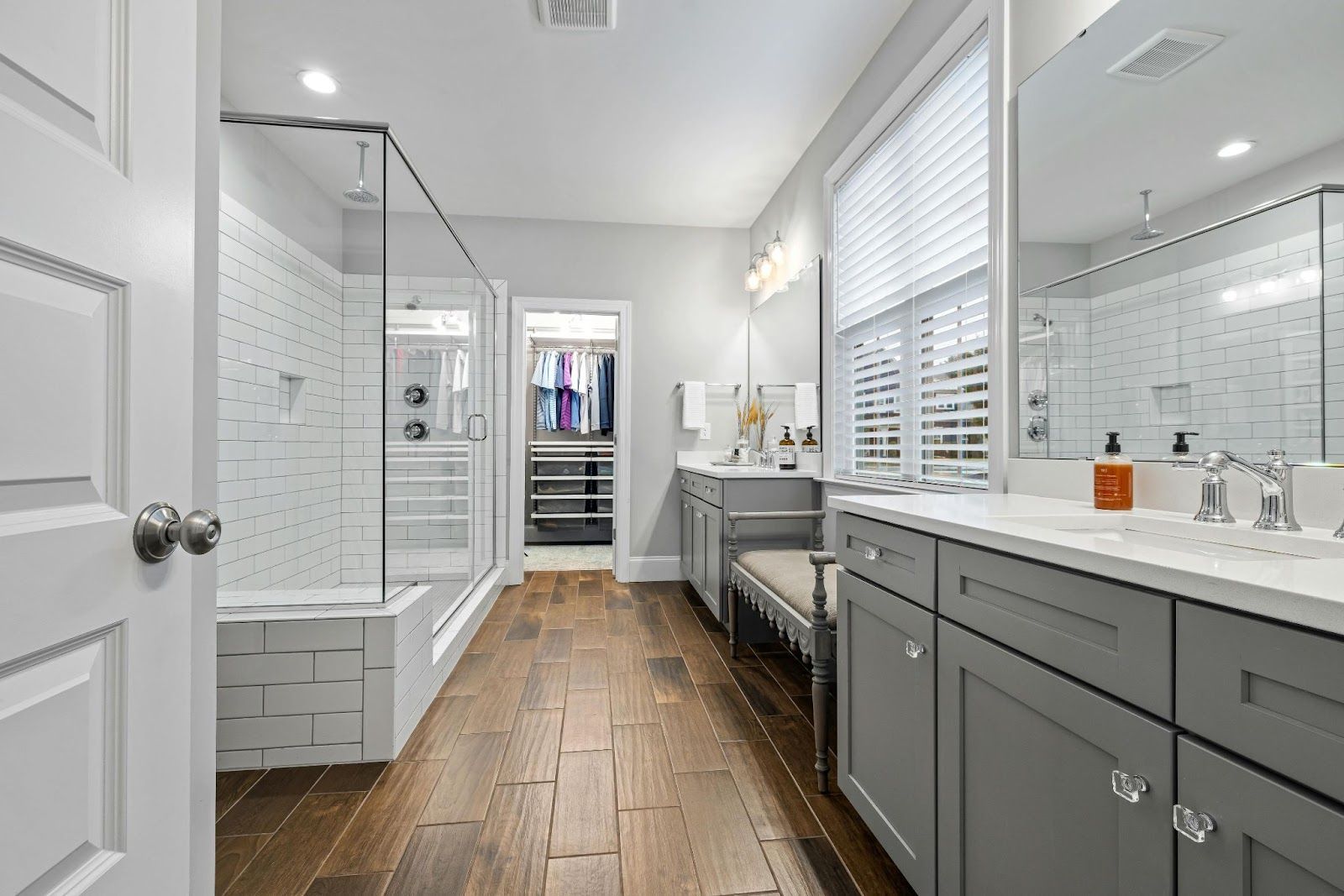 A bathroom with two sinks and a walk in shower.