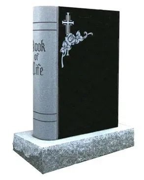 Black and gray book-shaped gravestone with a cross and floral design on a base