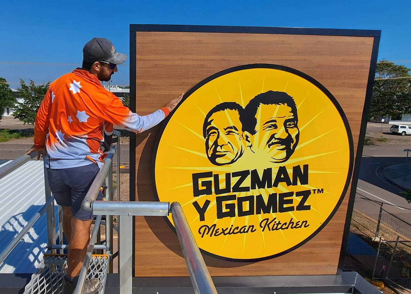 Man setting up the sign board — Electricians in Palmerston, NT