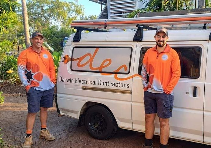 Man smiling and standing besides the van — Electricians in Palmerston, NT