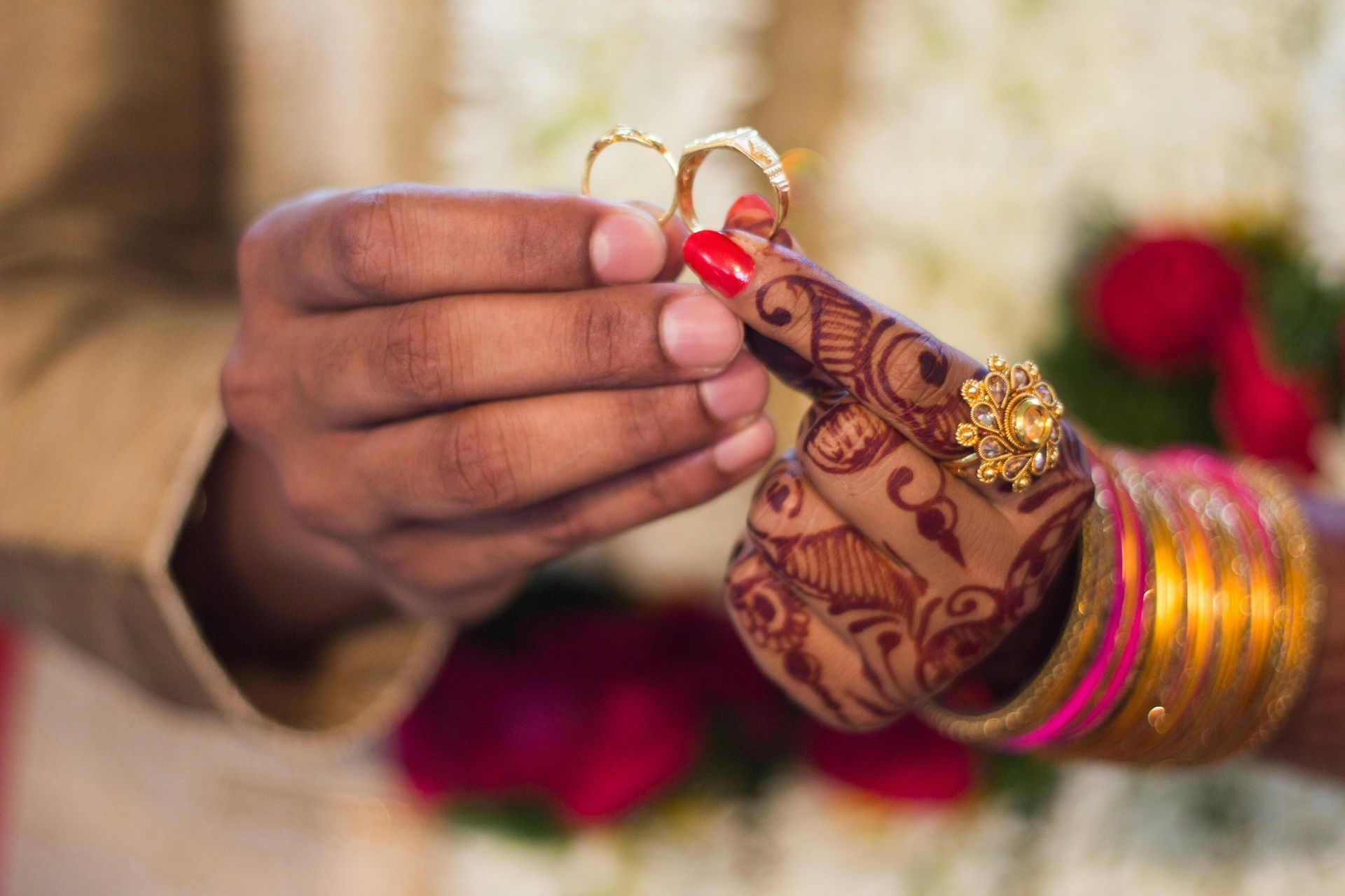 A man is putting a wedding ring on a woman 's finger.