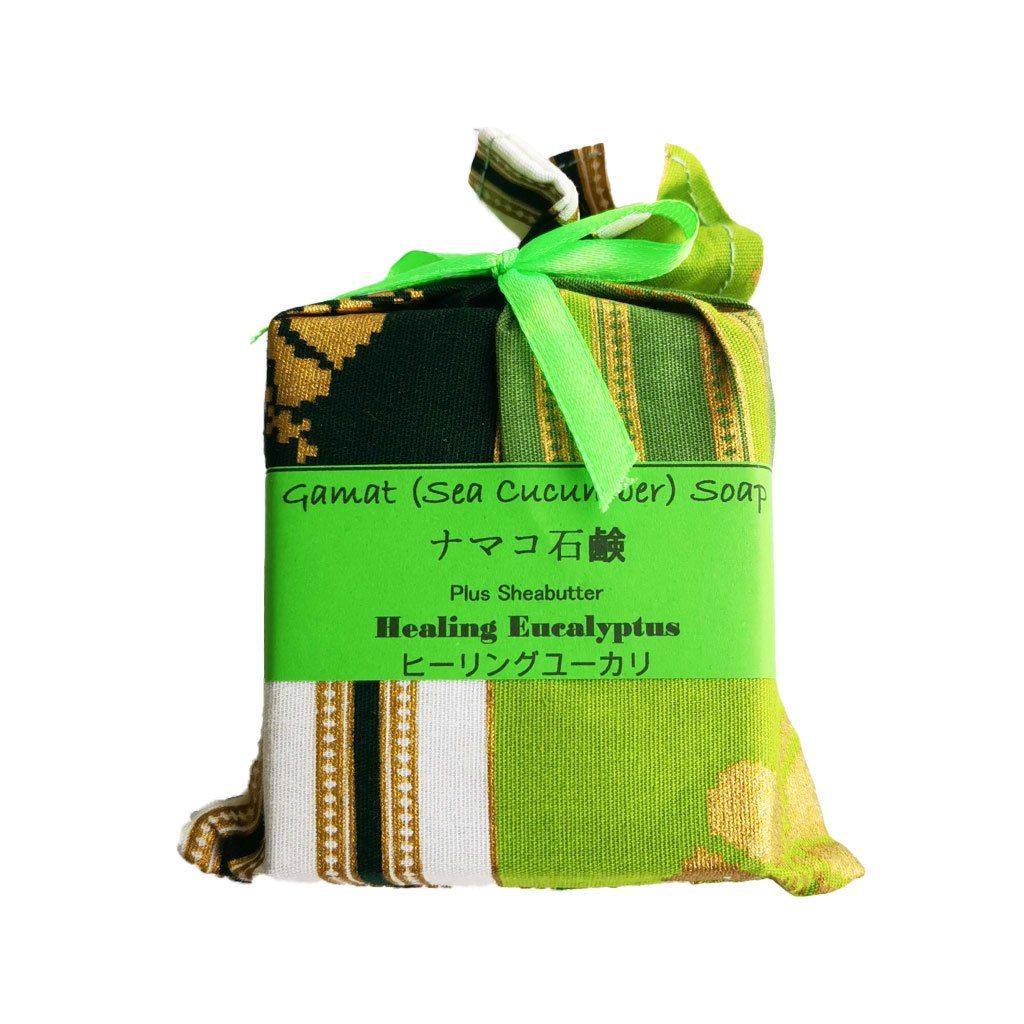 Wrapped soap bar in green and patterned fabric, tied with a green ribbon; label reads 