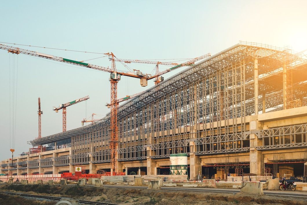 A large building is being built with cranes in the background.