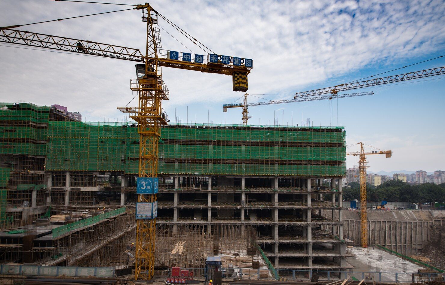 A large building is being built with cranes and scaffolding.