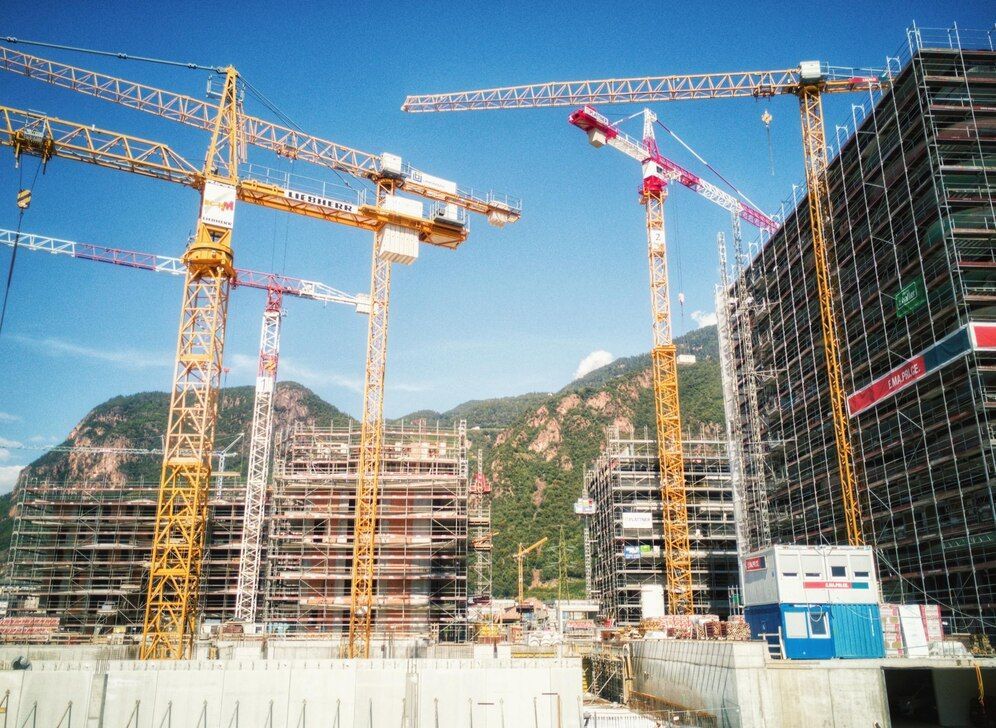 A construction site with a lot of cranes and scaffolding.