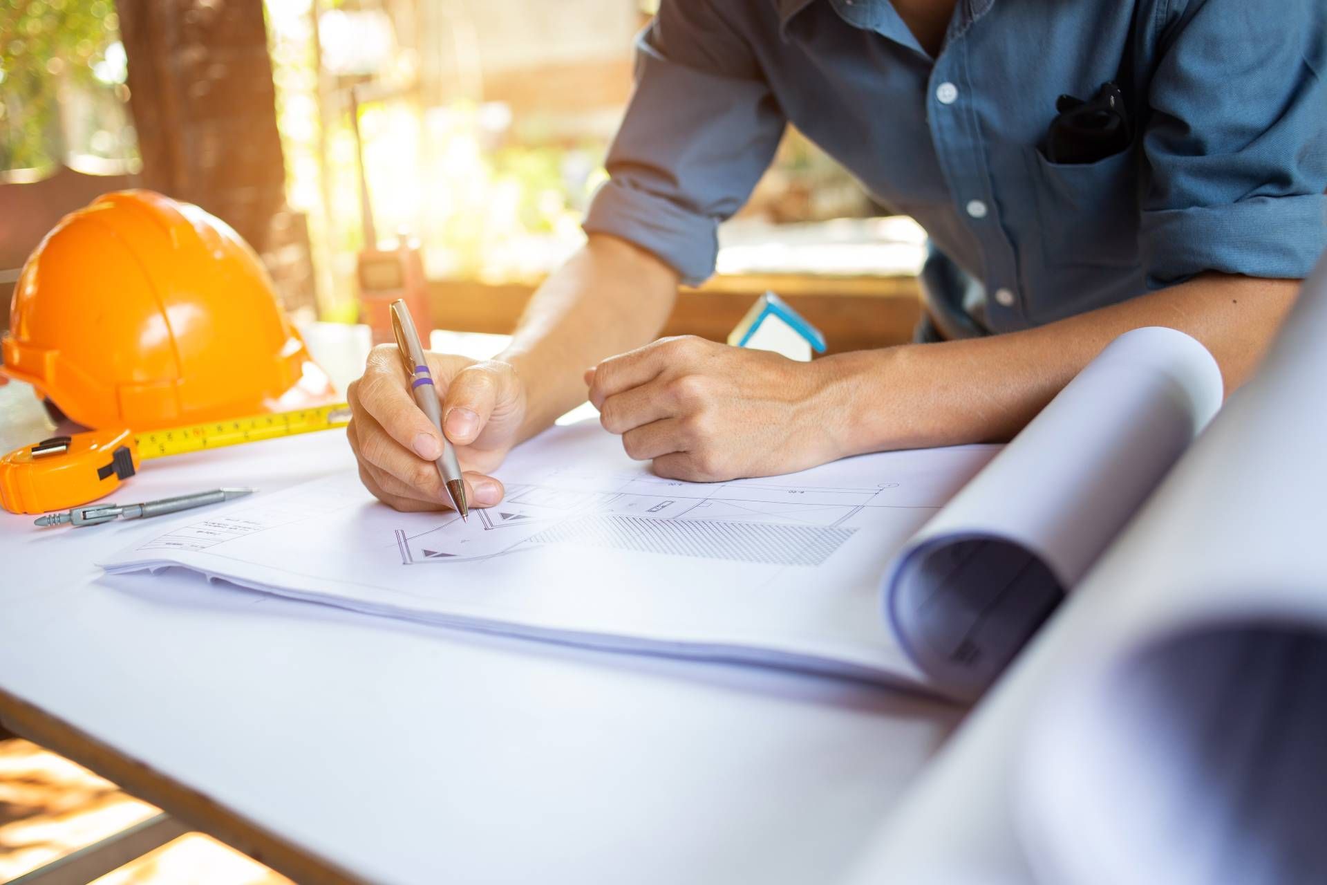 A man is sitting at a table writing on a piece of paper.