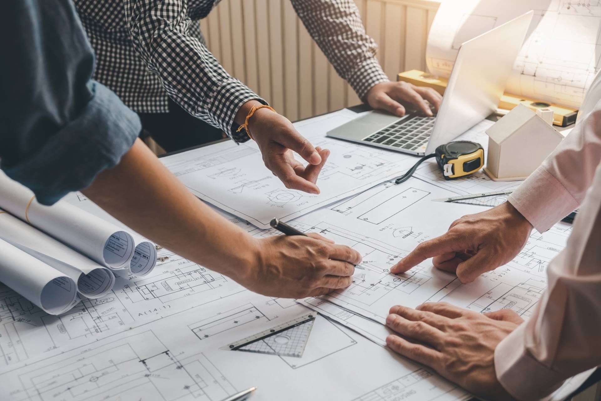 A group of people are looking at a blueprint on a table.