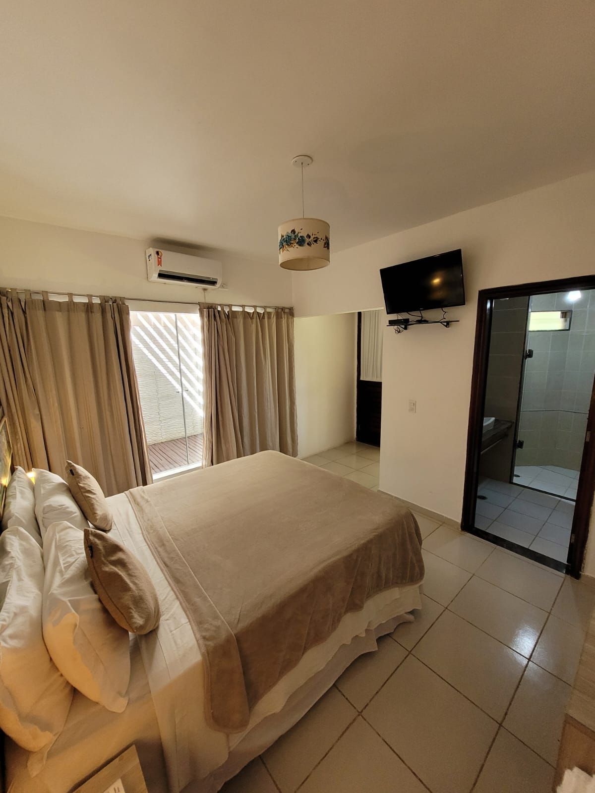 Um quarto de hotel com uma cama king size e uma TV de tela plana.