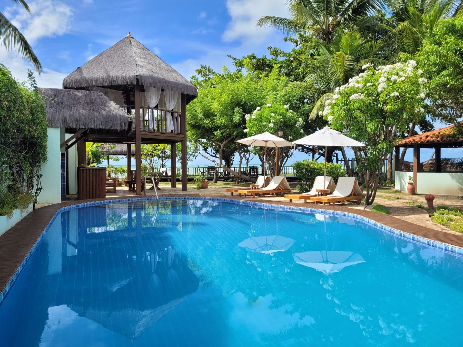 Uma grande piscina com cadeiras e guarda-sóis ao redor