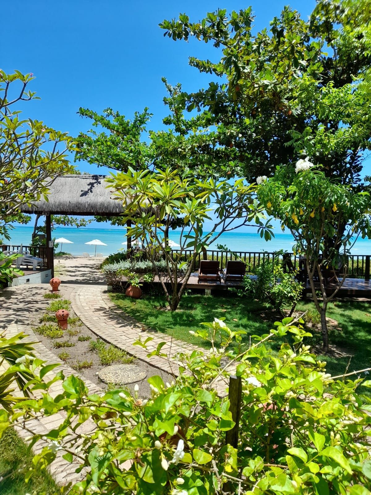 Um caminho que leva a uma praia com um mirante ao fundo