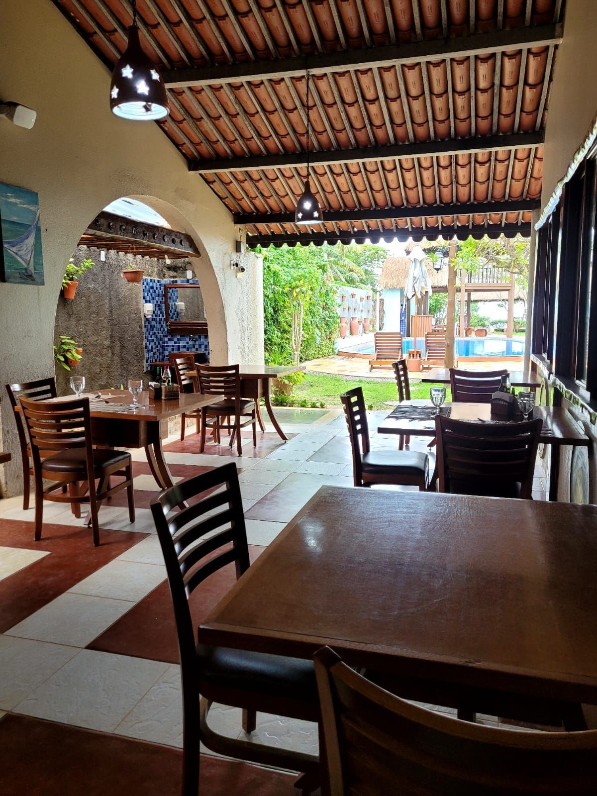 Um restaurante com mesas e cadeiras sob um teto.