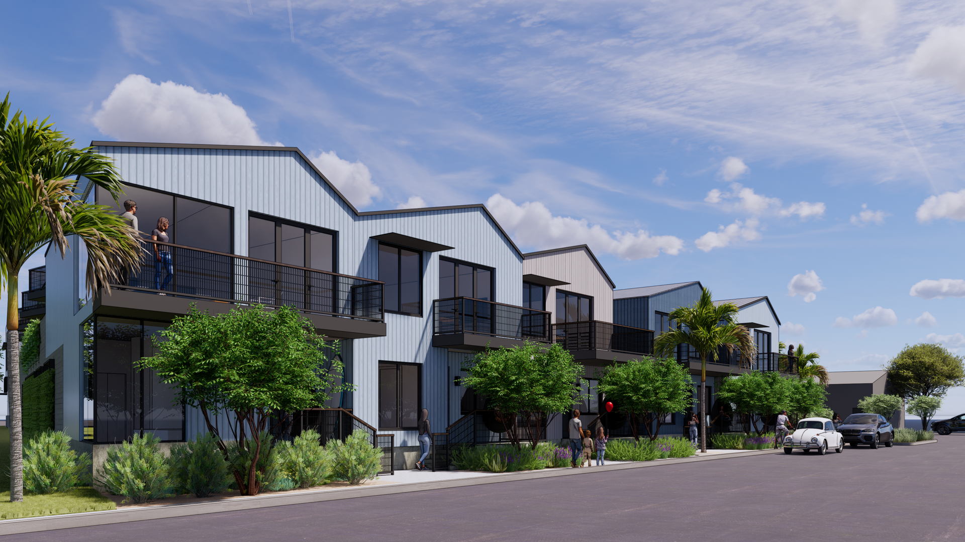 Row of modern townhouses with light blue metal siding, balconies, and street view.