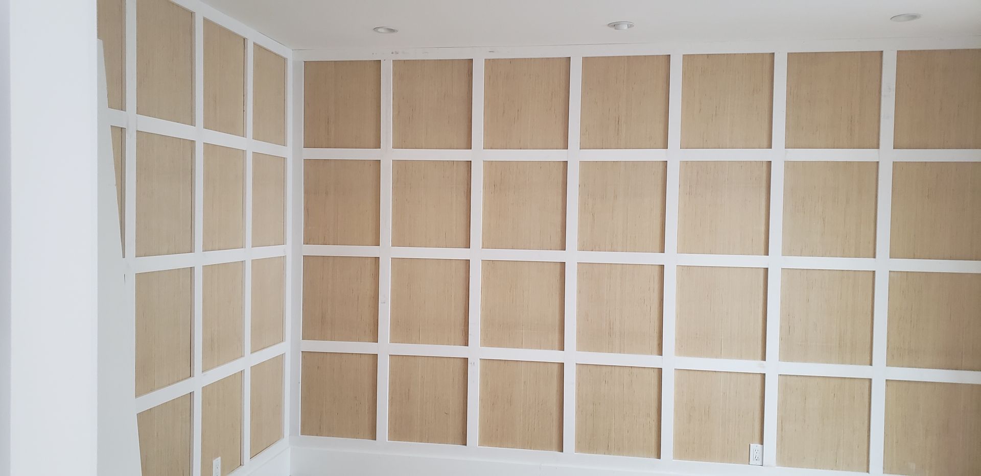 Carpenter working on stained glass window frames in workshop.